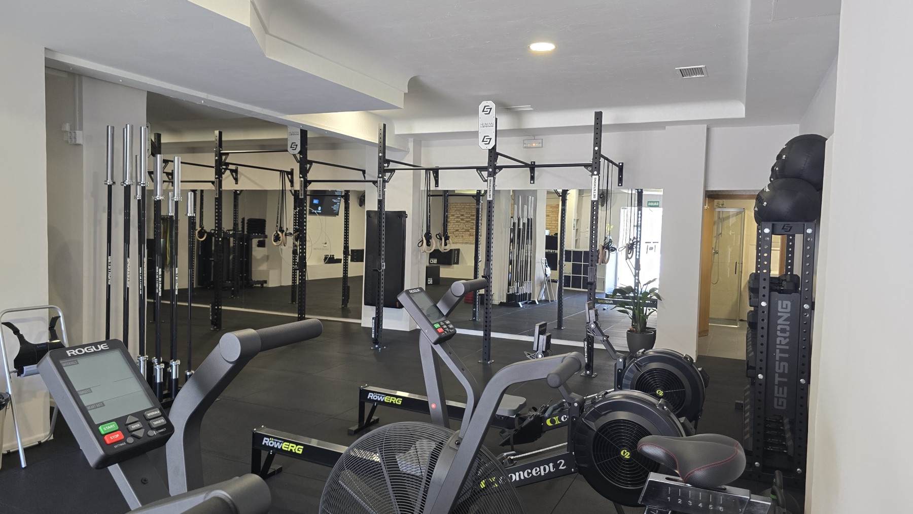 Zona de entrenamiento funcional con racks, anillas y material de fuerza